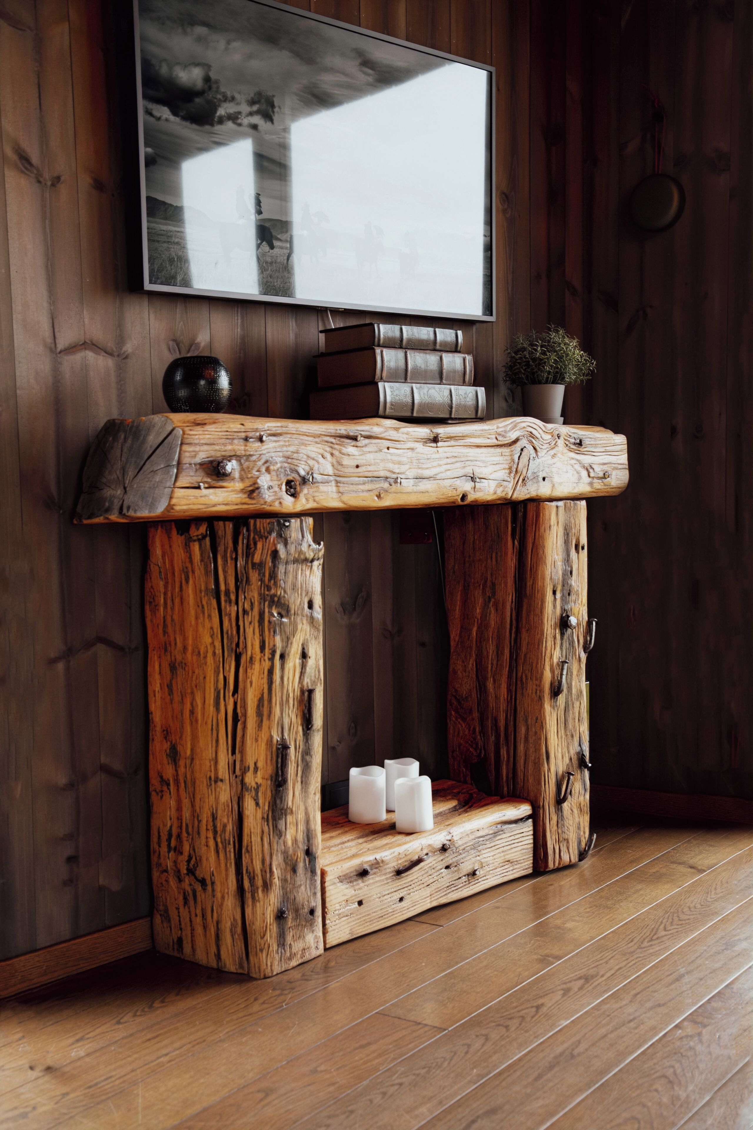Une console en bois rustique, avec un téléviseur fixé au-dessus.