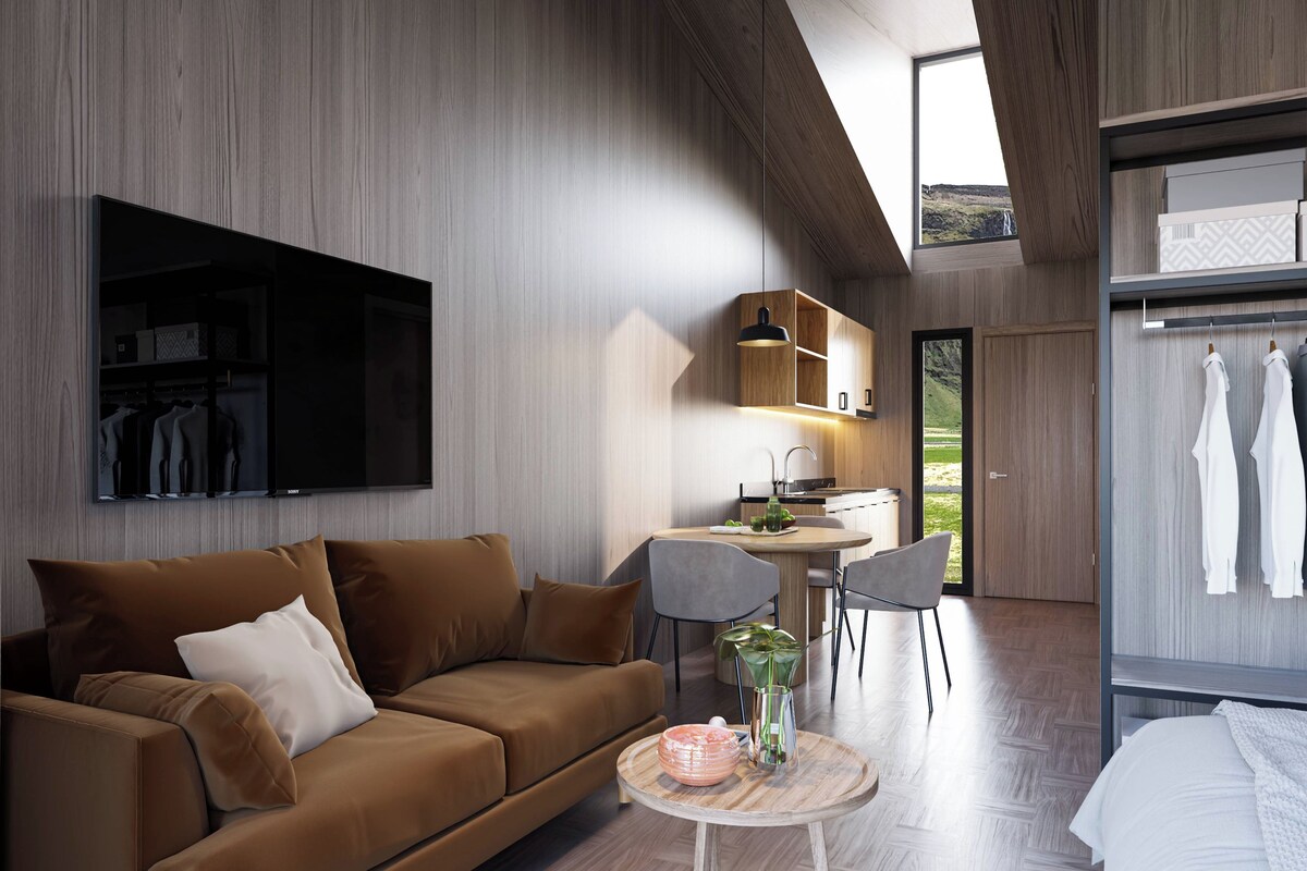 A modern interior with a sofa, a dining table, a kitchen area, and a wardrobe.
