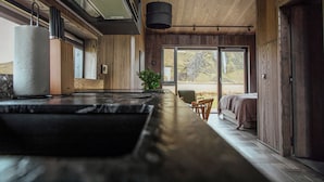 A modern interior with a wooden ceiling, a large window, and a bed with a view. - Seljalandsfoss Horizons (Rangárþing eystra)