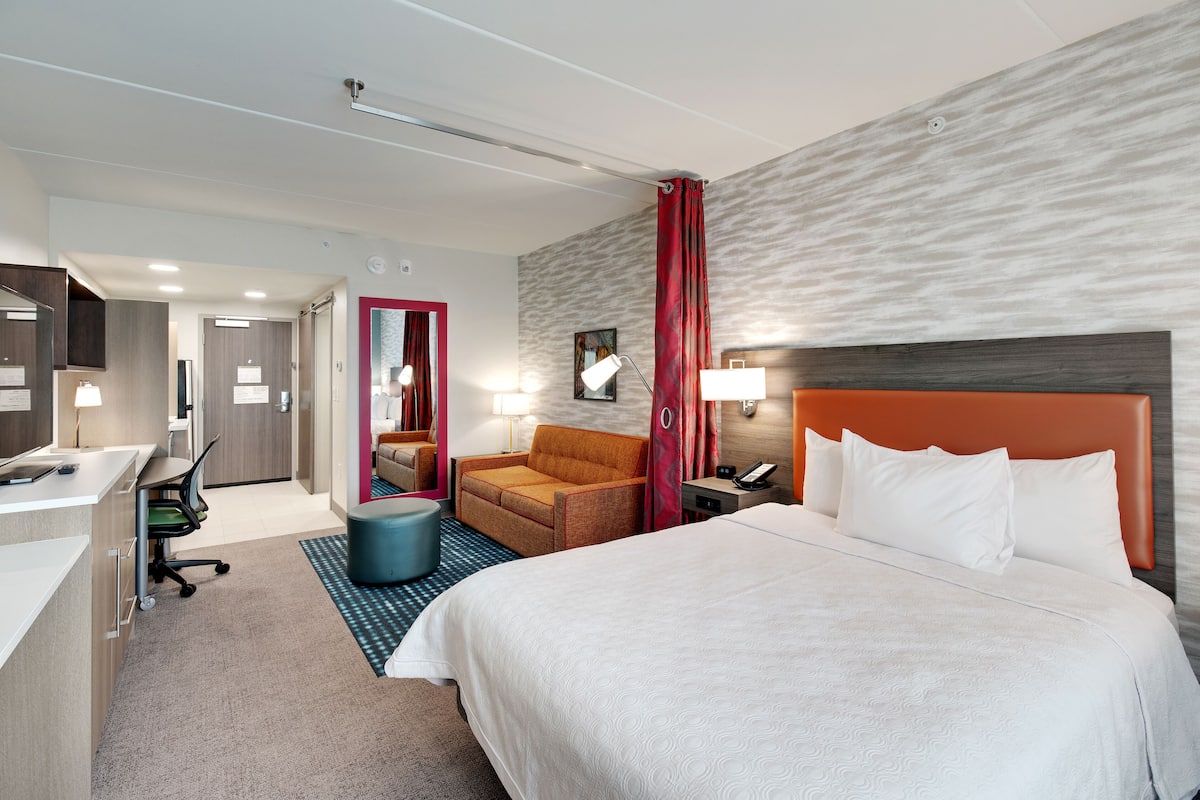 Une chambre d’hôtel comprenant un lit, un bureau, une chaise, un canapé et une salle de bain.