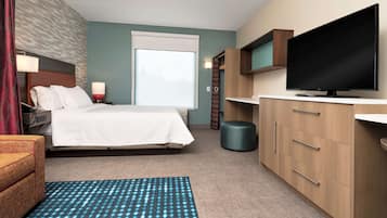 Une chambre d’hôtel avec un lit, une télévision, un bureau et une chaise.