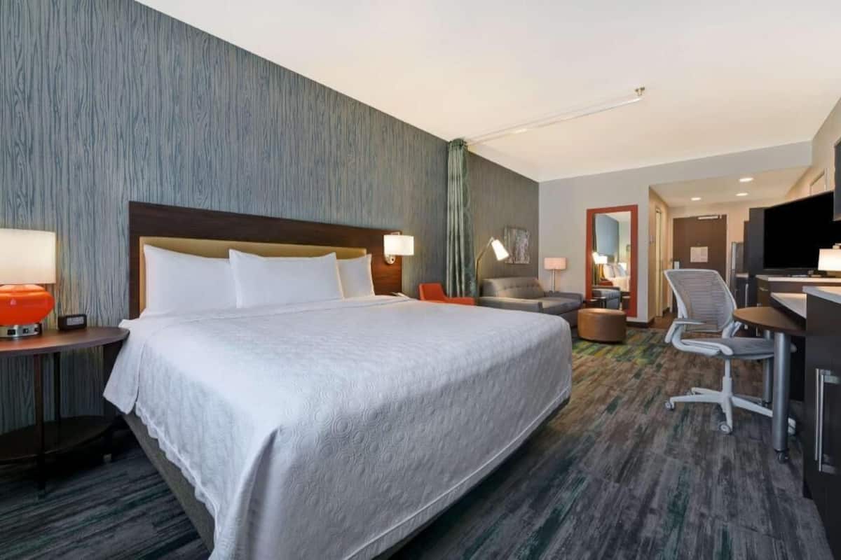 Een hotelkamer met een groot bed, een bureau, een stoel en een televisie.