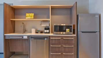 Una cocina compacta equipada con lavavajillas, microondas y refrigerador.