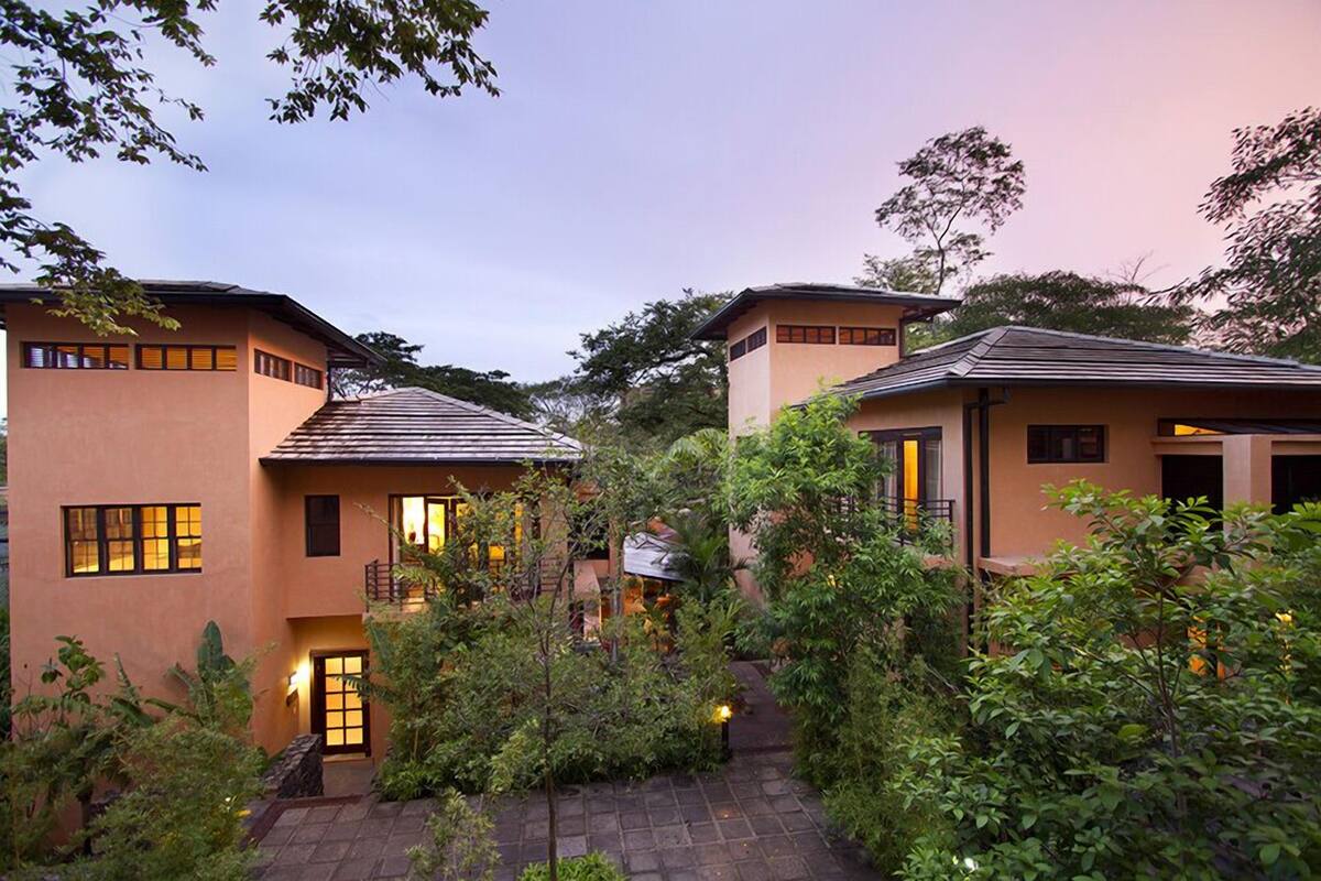 A modern building with a courtyard surrounded by lush greenery.