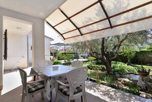 An outdoor patio with a table and chairs, surrounded by a garden with various plants and a small water feature. - Apartment 108/216 (Istria - Valbandon), 700m from the beach (Valbandon)