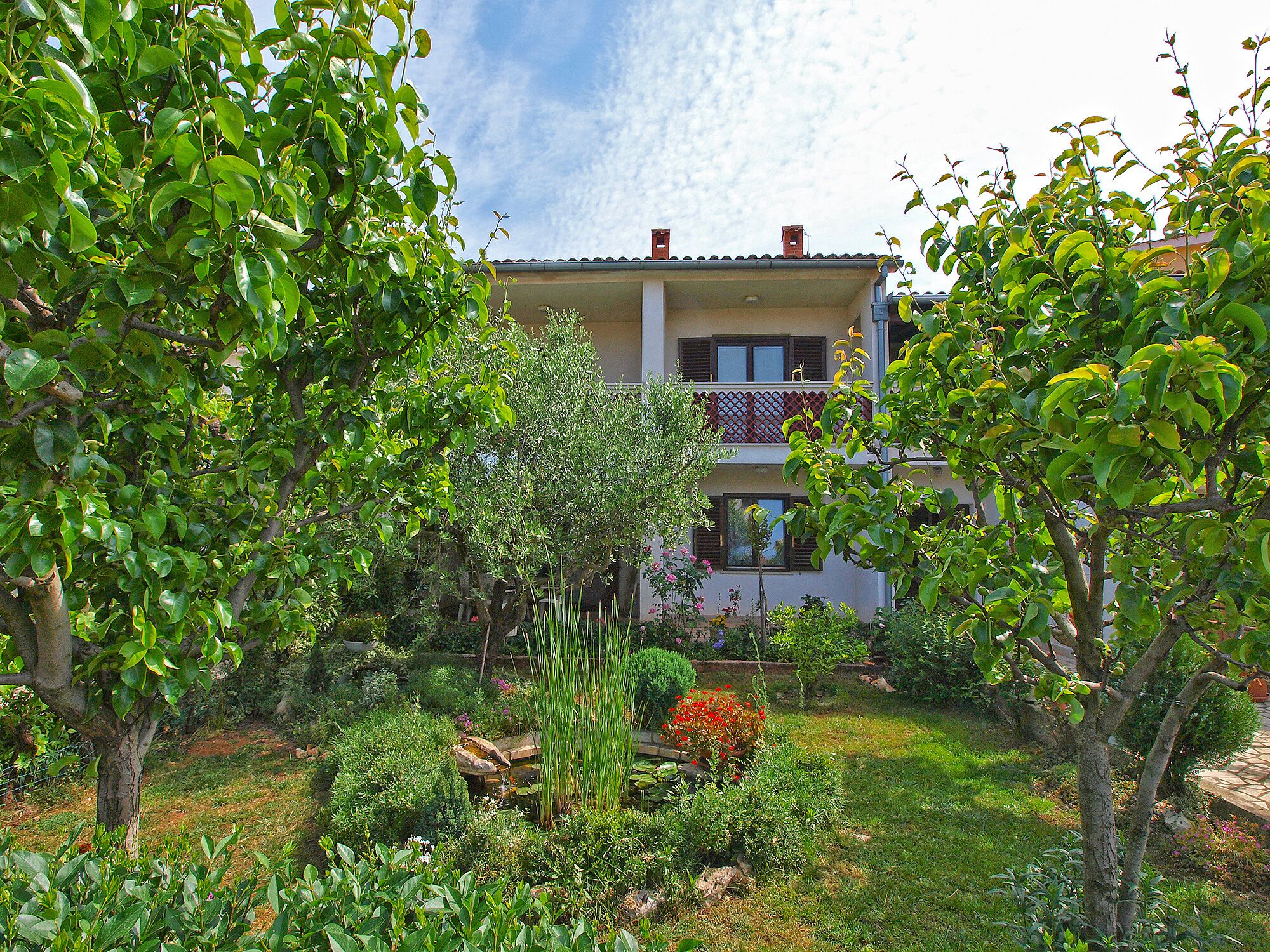 A two-story building with a garden in front.