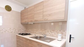 A modern kitchen with light wood cabinets, a stainless steel sink, and a gas stove. - Apartment 154/328 (Istria - Rabac), 300m from the beach (Rabac)