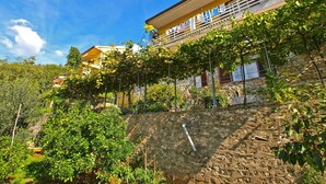 A two-story house with a stone wall and a balcony with clothes hanging. - Apartment 154/328 (Istria - Rabac), 300m from the beach (Rabac)
