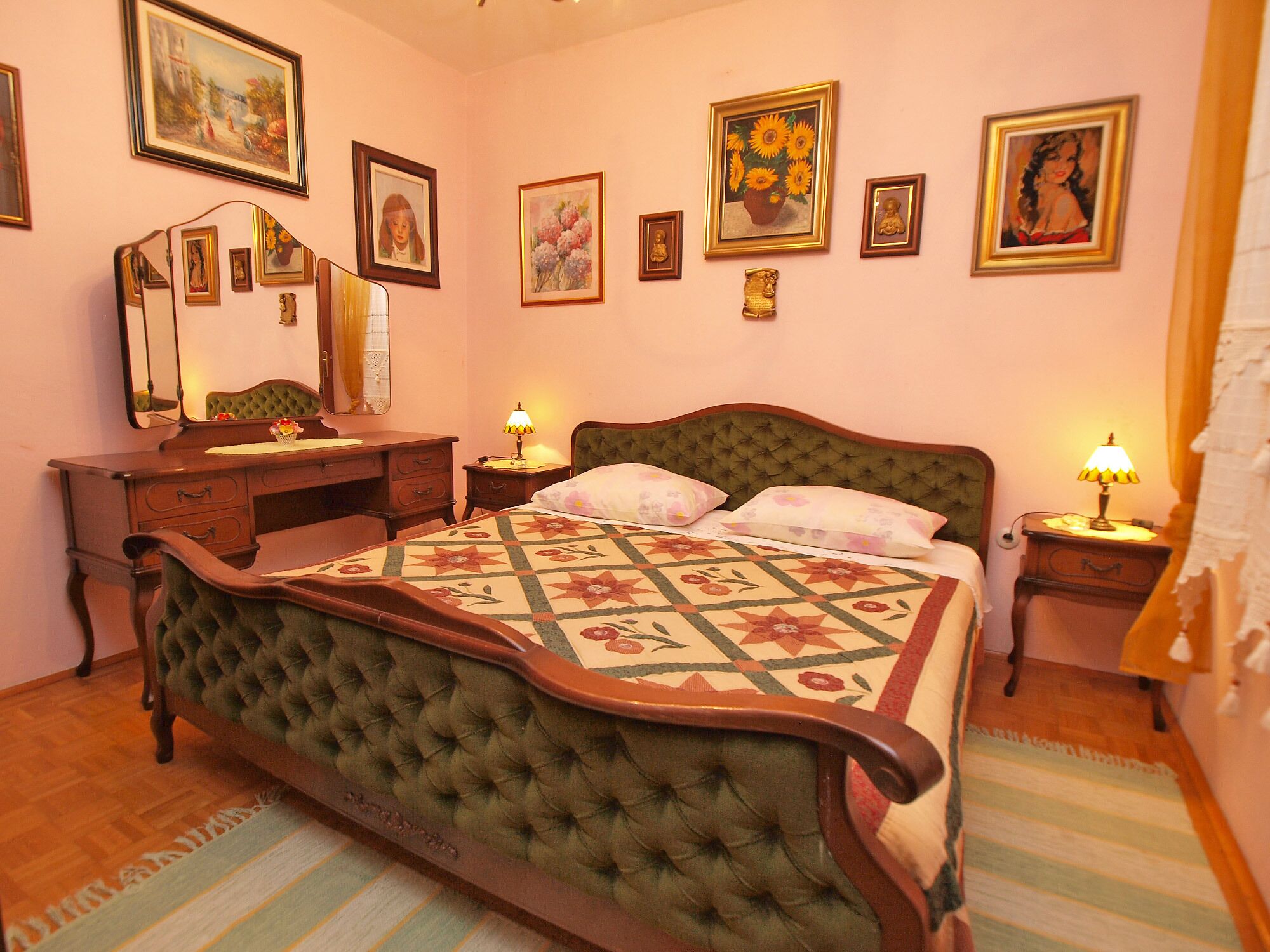 A bedroom with a bed, a dresser, a desk, and a mirror.
