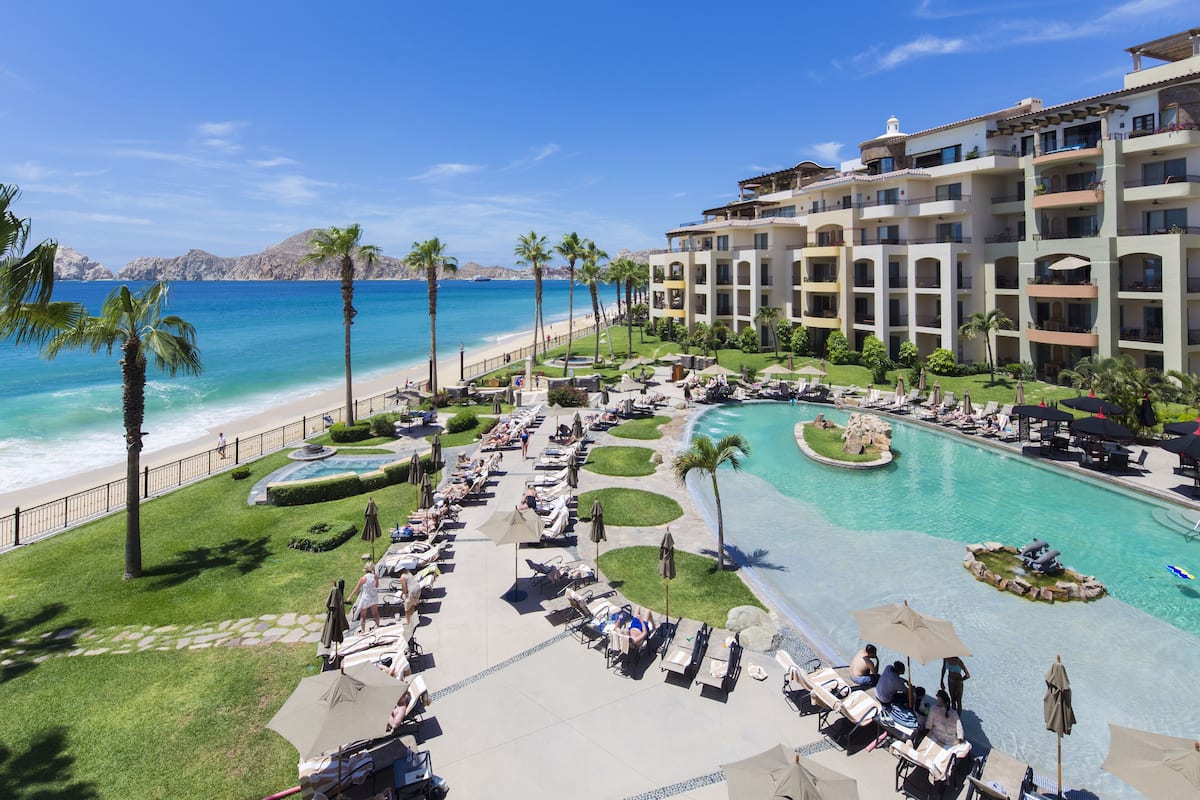 Un resort con piscina, playa y vistas al océano.