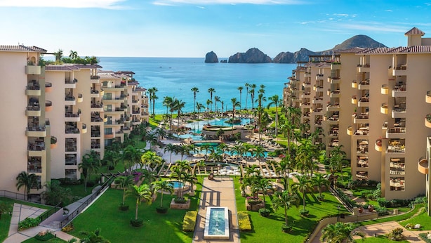 A resort with multiple buildings, a central pool area, and a view of the ocean. - Cabo La Estancia (Cabo San Lucas)