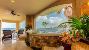 A modern interior with a stone wall, a hot tub, and a view of the ocean. - Cabo La Estancia (Cabo San Lucas)