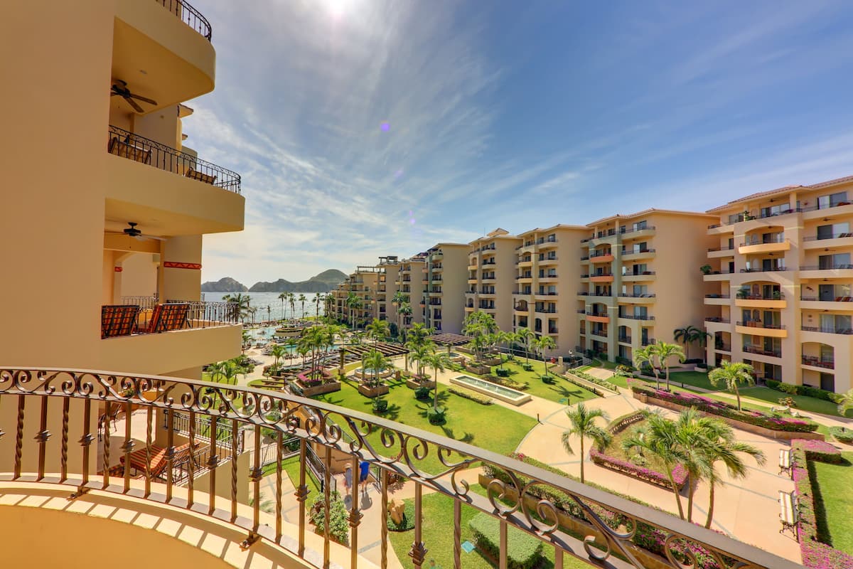 Un hotel con varios balcones, una zona de piscina y vistas al mar.