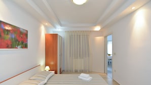 Une chambre d’hôtel avec un lit, une table de chevet, une lampe, un tableau et une vue sur la salle à manger.