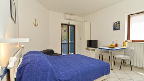 A bedroom with a bed, a desk, a chair, a television, and a window. - Apartment 242/544 (Istria - Fažana), 200m from the beach (Fažana)