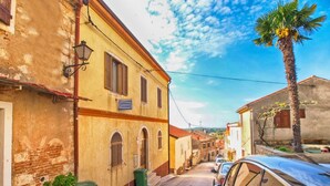 A narrow street lined with traditional buildings, a parked car, and a palm tree. - Apartment 271/602 (Istria - Vrsar), 1000m from the beach (Vrsar)