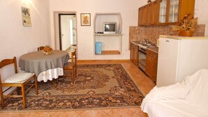 A compact kitchen with a dining area, a small TV, and a refrigerator. - Apartment 271/602 (Istria - Vrsar), 1000m from the beach (Vrsar)