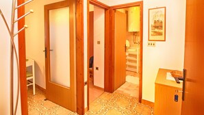 A hallway with wooden doors, a radiator, a framed picture on the wall, and a small cabinet with a key. - Apartment 279/619 (Istria - Vrsar), 100m from the beach (Vrsar)