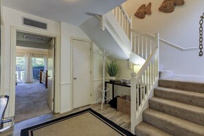 Enter a beautifully appointed space with a neutral color palette, complemented by a warm area rug and a stylish staircase.