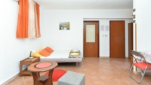 A small, bright room with a bed, a small table, a chair, and a door. - Apartment 295/2145 (Istria - Stinjan), 1000m from the beach (Stinjan)