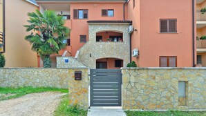 A two-story building with a stone facade, a gated entrance, and a small balcony with potted plants. - Apartment 295/2145 (Istria - Stinjan), 1000m from the beach (Stinjan)