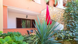 A building with a stone facade, a red flag, and lush greenery. - Apartment 295/2145 (Istria - Stinjan), 1000m from the beach (Stinjan)