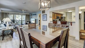 Un amplio salón con una gran mesa de comedor, asientos cómodos y vistas al exterior.