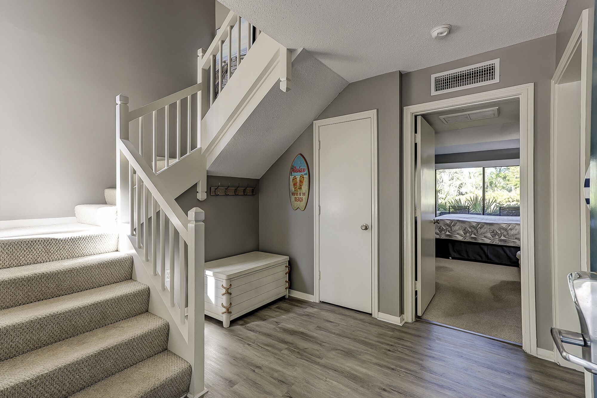 A staircase leading to a loft bedroom with a view of the outdoors.
