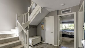 A staircase leading to a loft bedroom with a view of the outdoors.