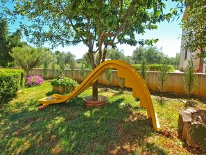 Stroll through a serene garden oasis, featuring a vibrant sculpture and lush greenery.