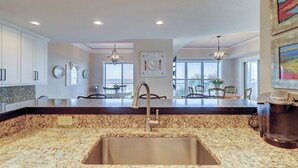 A kitchen with granite countertops, stainless steel sink, and pendant lighting. - The closest Hampton Place villa to the beach! Only steps from the ocean! (Hilton Head Island)