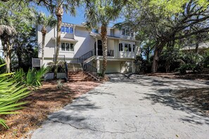 A two-story house with a front entrance, a staircase, and a driveway.
