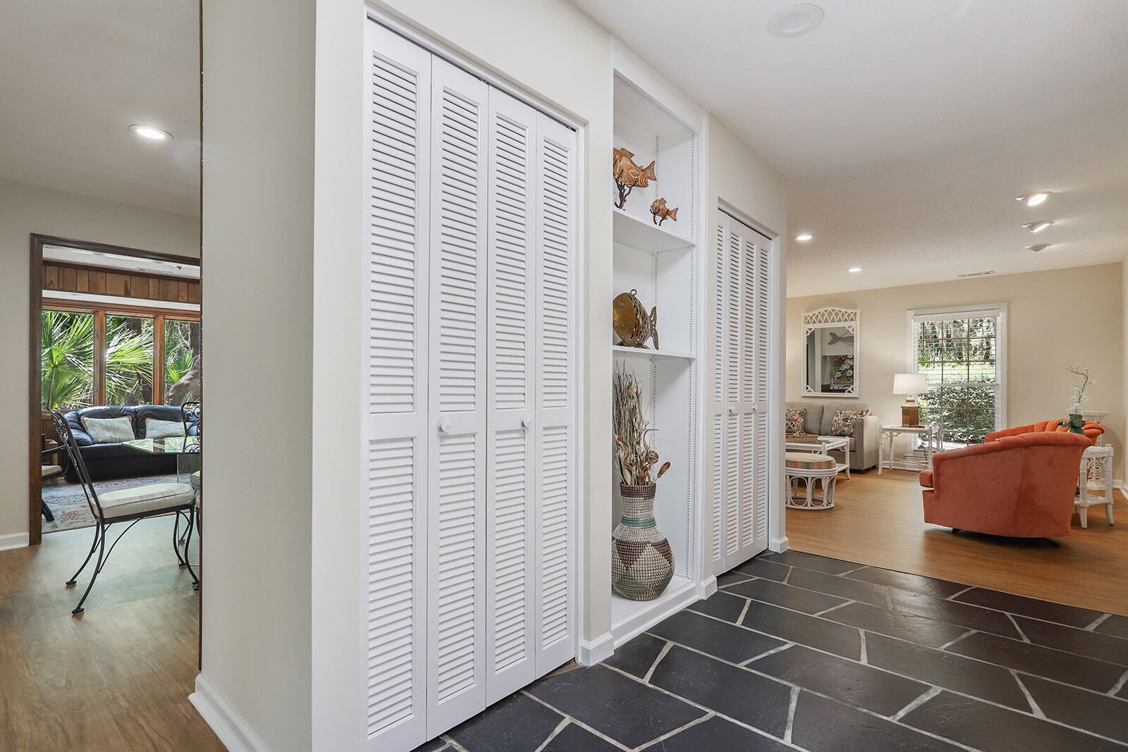 A spacious living area with a large window, a dining area, and a seating area with a sofa and chairs.