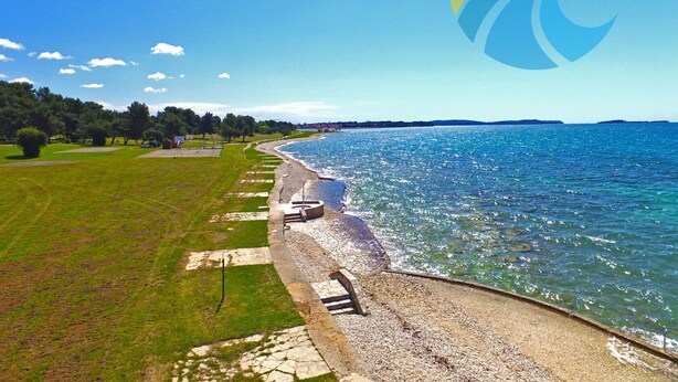 A coastal walkway with a stone railing, grassy areas, and a clear view of the sea. - Apartment 349/808 (Istria - Peroj), 700m from the beach (Peroj)