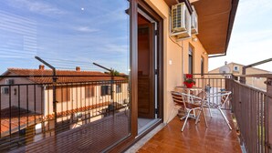 A balcony with a table and chairs, a potted plant, and an air conditioning unit. - Apartment 349/809 (Istria - Peroj), 700m from the beach (Peroj)