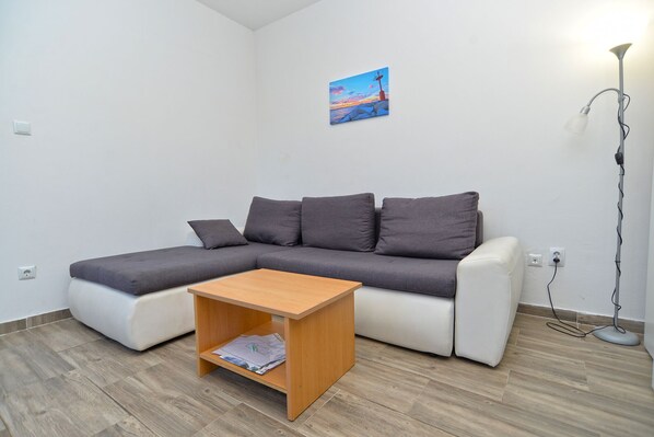 A modern living room with a grey sectional sofa, a wooden coffee table, and a floor lamp. - Apartment 351/817 (Istria - Fažana), 300m from the beach (Fažana)