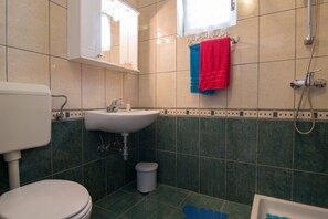 A bathroom with a toilet, sink, and shower.