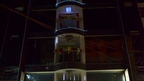 A hotel with a modern design, featuring a prominent vertical tower with balconies adorned with lights and flowers. The hotel's name, "Grand Latino," is visible on the facade. - Hotel Grand Latino Ibague (Ibagué)