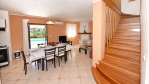 A dining area with a table set for four, a TV, and a fireplace. - House 377/857 (Istria - Sveti Lovreč), 18000m from the beach (Sveti Lovreč)