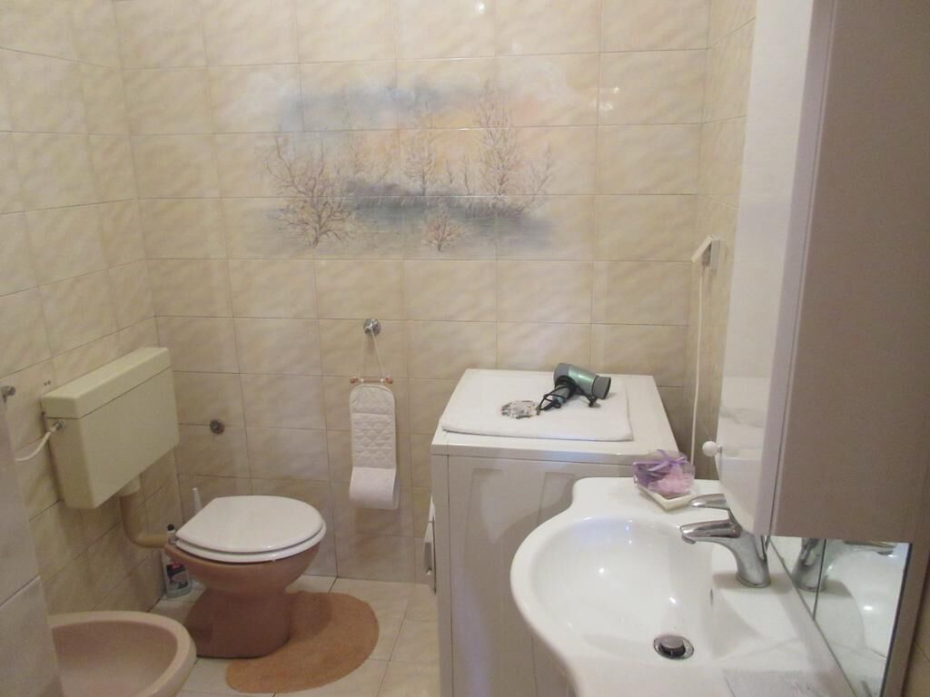 A bathroom with a toilet, sink, and a towel rack.
