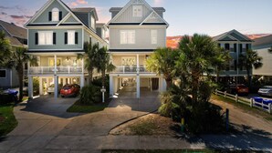 A two-story residential building with a covered walkway and a driveway. - 7BR Home Near Surfside Pier w/ Private Pool & Wi-Fi (Surfside Beach)
