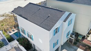 A two-story house with a dark roof, a swimming pool, and a beach view. - Retreat w/ Private Pool & Ocean Views, 4BR, Pet-Friendly (Surfside Beach)