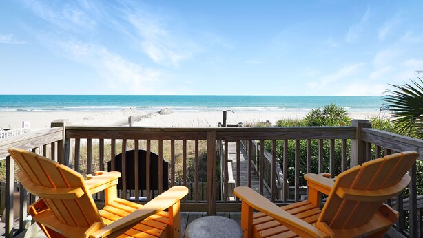 A wooden deck with two orange Adirondack chairs facing a beach. - Retreat w/ Private Pool & Ocean Views, 4BR, Pet-Friendly (Surfside Beach)