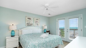 A bedroom with a bed, two wall-mounted lamps, a ceiling fan, and a balcony door. - Retreat w/ Private Pool & Ocean Views, 4BR, Pet-Friendly (Surfside Beach)