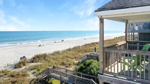 A beach view from a wooden deck with a view of the ocean and beach. - Retreat w/ Private Pool & Ocean Views, 4BR, Pet-Friendly (Surfside Beach)