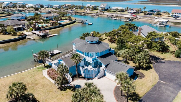 A coastal residential area with a prominent blue house featuring a circular tower, surrounded by water and other houses. - Inlet Front 5BR Home w/ Private Dock & Walk to Beach (Garden City Beach)