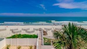 A beach with a wooden boardwalk leading to the shore, clear skies, and the ocean. - 7BR Beach House with Private Pool and Beach Access (Garden City Beach)