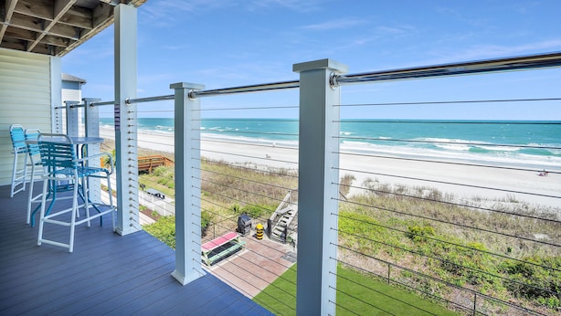 A wooden deck with outdoor furniture overlooking a beach. - Condo w/ Beach Walkover & Resort Pool Access (Surfside Beach)
