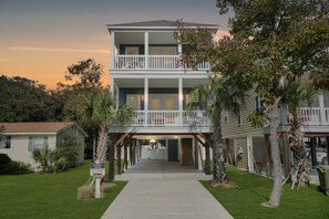 A two-story building with a balcony, a covered walkway, and a sign indicating a summer beach resort. - Walk to Beach 5BR Home w/ Private Pool & Beach Access (Surfside Beach)