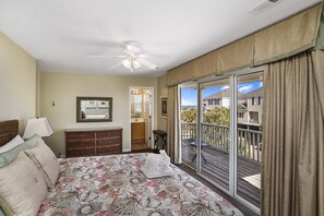A bedroom with a bed, dresser, and a view of a balcony. - Ocean View Duplex Near Surfside Pier - 5 Bedrooms, Sleeps 14 (Surfside Beach)
